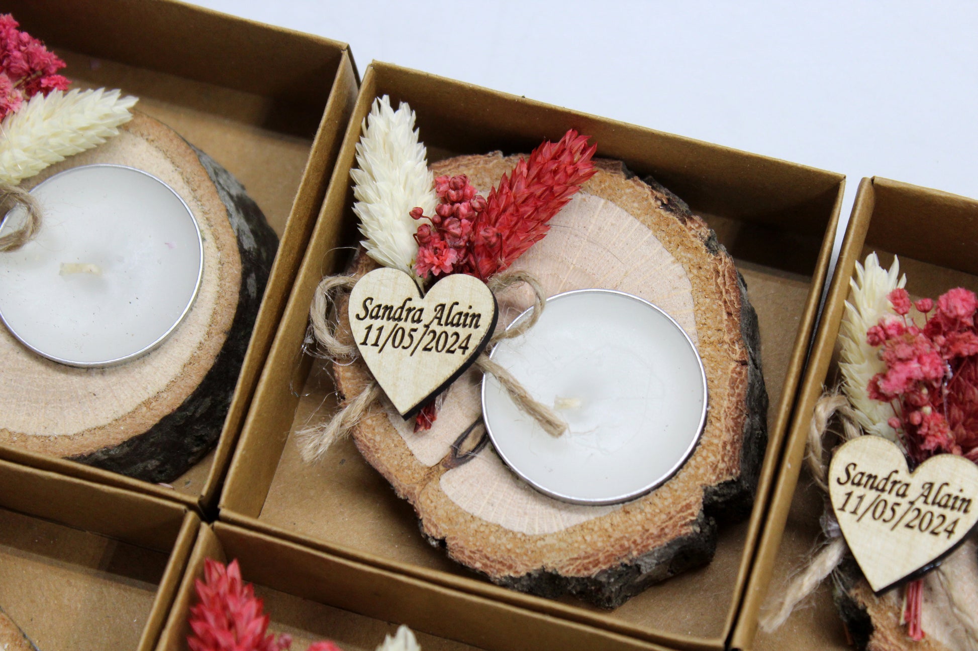 Charming and rustic wedding favor featuring a personalized wooden candle holder with dried flowers. The engraved heart tag with "Sandra Alain, 11/05/2024" adds a bespoke touch, making it a perfect keepsake for guests. The natural wood slice base complements the romantic floral arrangement, creating a memorable and elegant decor piece.