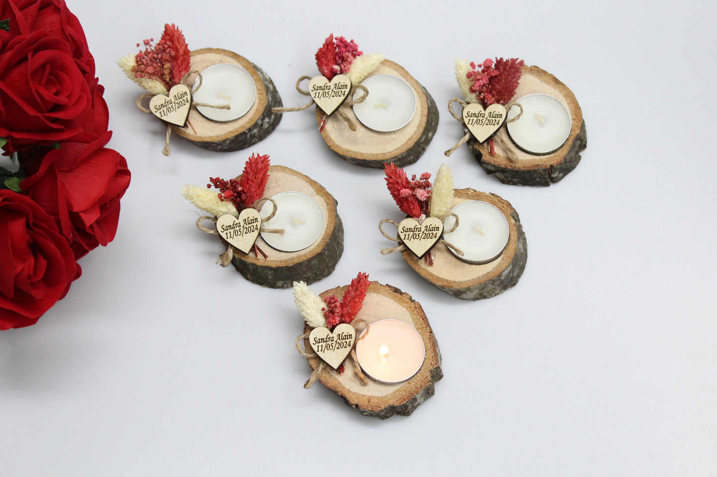 Handcrafted wooden candle holders featuring rustic wood slices, adorned with dried flowers and a custom engraved heart tag showcasing names and dates as examples. These artisanal wedding favors exude a natural charm, perfect for adding a bespoke touch to your celebration decor. Ideal for creating a warm and memorable atmosphere, each piece is a unique keepsake for your guests.