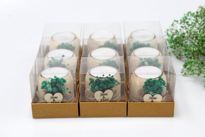 Boxed set of nine rustic wooden candle holders adorned with lush green dried flowers, each featuring a custom heart tag with names as an example. Perfect for adding a personalized, nature-inspired touch to any event or celebration.