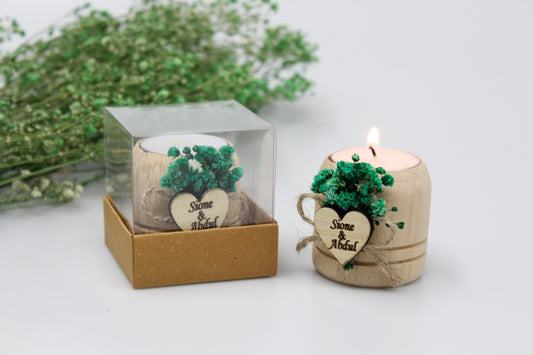 Rustic elegance meets bespoke charm in this display of personalized wooden candle holders, adorned with green dried flowers. Each handcrafted piece features a custom engraved heart tag with names and dates as examples, making them perfect for adding a touch of personalized sophistication to any event.