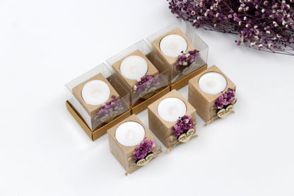 Personalized wooden candle holder wedding favors with purple dried flowers, featuring customizable names and date example 'Jenna & Alex 5/4/2024,' displayed in clear packaging and unboxed. Arranged in two rows, with additional dried flowers in the background.