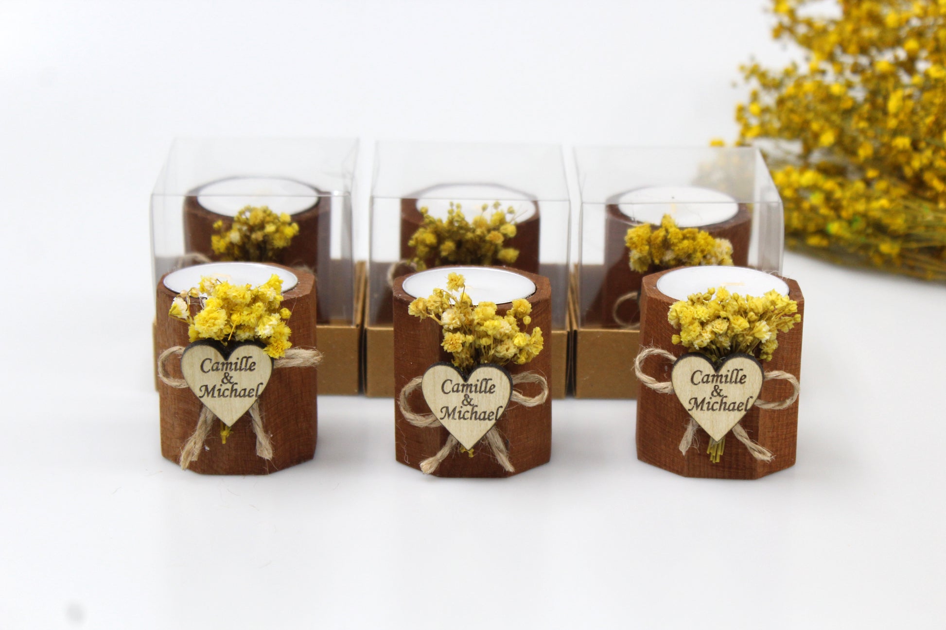Personalized rustic wedding candle favors with engraved heart tags and dried flower accents, beautifully packaged. Custom wooden tealight holders featuring names Camille & Michael, perfect for elegant and charming wedding decor and gifts